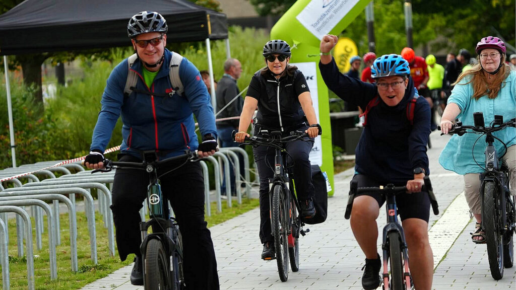 Teilnehmende der Großen Weserrunde fahren mit Fahrrädern und E-Bikes auf der Veranstaltungsstrecke.